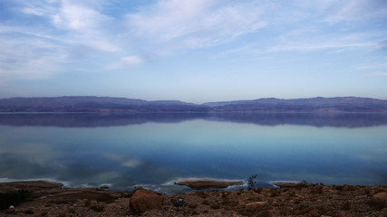 Beautiful sea mounts and sky clouds landscape with reflection. Reflection of blue sky with clouds in calm water. Tranquil wild nature scene.