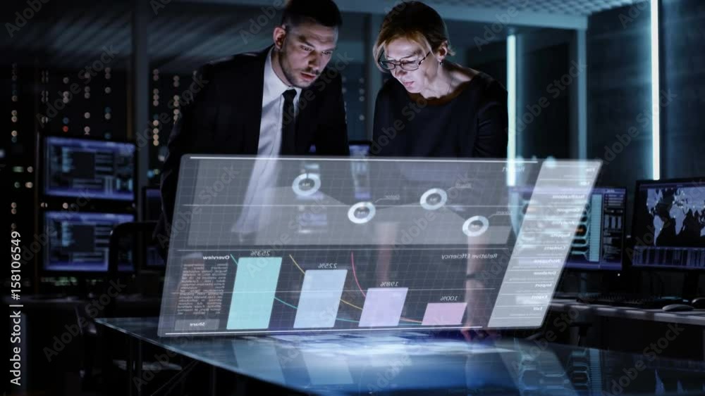 Aufkleber male and female business managers use touchscreen interactive 3d panel in big monitoring room full o