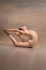 The female ballet dancer posing over gray background © master1305