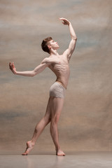 Fototapeta premium The male ballet dancer posing over gray background
