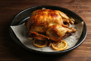 Homemade baked chicken with lemon on wooden table