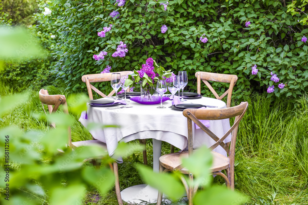 Wall mural table setting for dinner in beautiful lilac garden