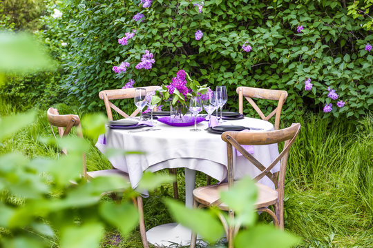 Table setting for dinner in beautiful lilac garden