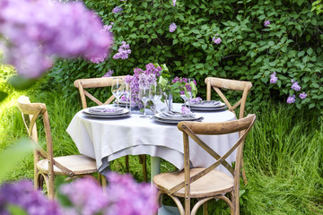 Table setting for dinner in beautiful lilac garden