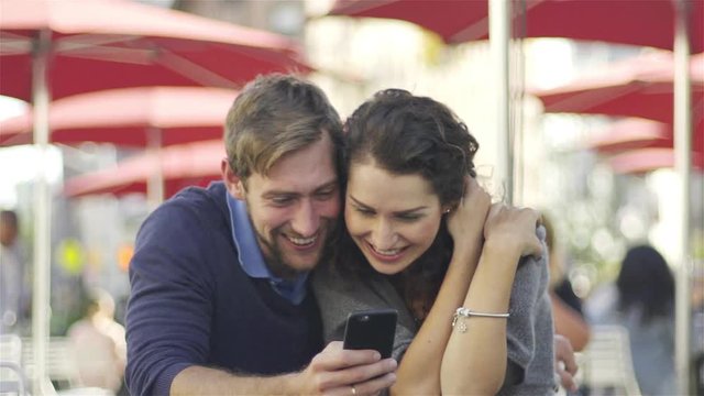 Couple laughing at content on smart phone
