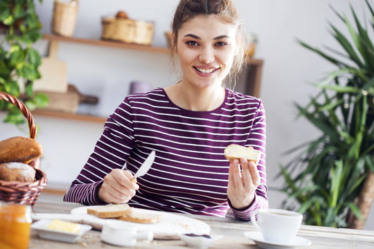 Young woman eating bread with butter