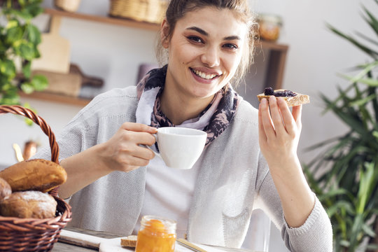 Young woman eating toast bread with jam
