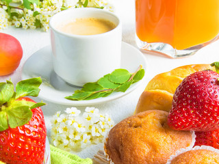 Breakfast with coffee, apricot juice, strawberry, fresh pastry muffin on whitecolored background concept of healthy food