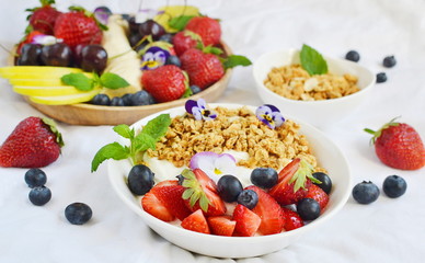 Yogurt with granola and fruits, blueberries, strawberries, cherry, apple, banana, healthy breakfast