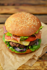 Burger with bacon on wooden table