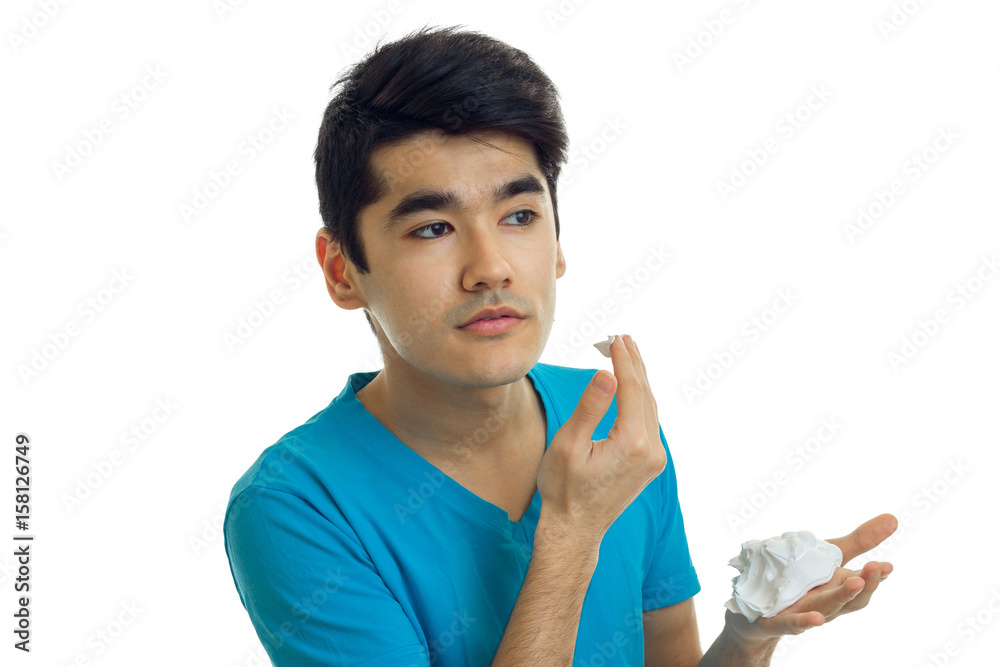 Wall mural young guy with black hair looks away and causes the person shaving foam