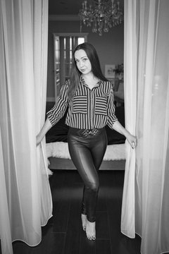 Smiling girl between curtains, a black and white frame