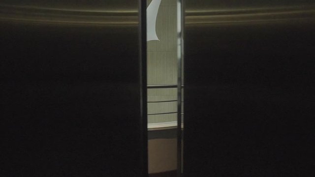 Slow motion POV shot exiting elevator and looking down at lobby in luxury hotel