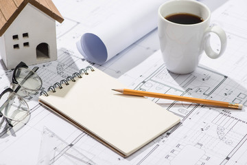 Construction projects. Planning. Open blueprints with a pencil and notebook.