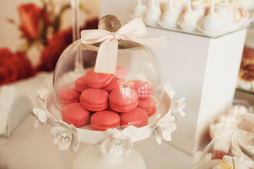 Pink macaroons served under glass cover