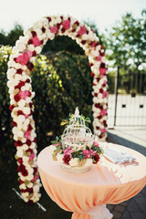 Table covered with pink cloth and decorated with white and red flowers