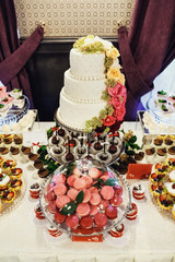 Red macaroons stand under glass cover on candy bar