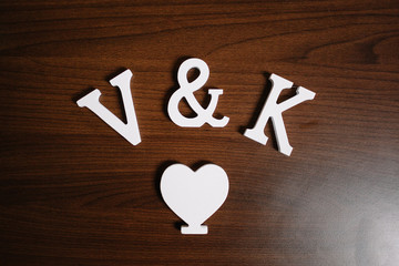 Initials 'V & K' and wooden heart lie on the table