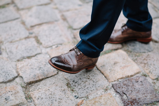 Man in leather shoes walks on the street