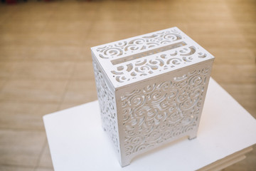 White chest with original design stands on a little table