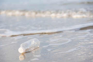 Empty plastic bottle on the beach in the morning.