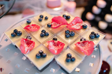 Glasses with berry cream desserts decorated with pink petals