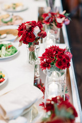 Red gerberas put in a glass cube stand on dinner table