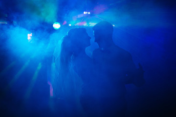 Wedding couple dances in blue light