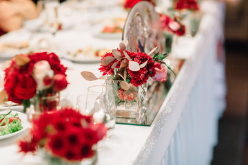 Red gerberas put in a glass cube stand on dinner table