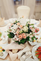 Gorgeous bouquet of pink roses stands in the middle of dinner table