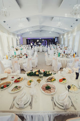 Round tables and white chairs stand in the bright hall