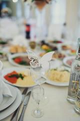 White butterfly stands on the wineglass