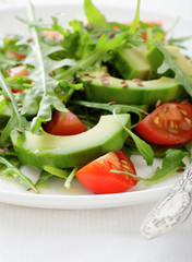 Green Salad with avocado, tomatoes and arugula closeup