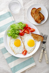 Breakfast - Fried Eggs, tomato, lettuce, bread and water glass