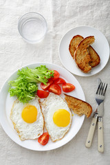 Breakfast - Fried Eggs with tomato, bread, lettuce and glass