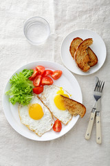 Breakfast - Fried Eggs with tomato, lettuce, bread and water glass