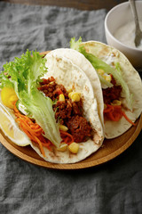 Two Mexican Tacos on a wooden plate