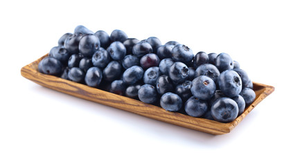 blueberries in wooden dish isolated on white