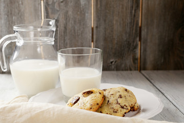 Milk and cookies on wooden background