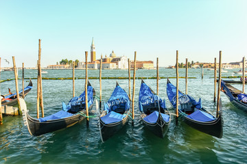 Fototapeta na wymiar Gondolas moored by Saint Mark square with San Giorgio di Maggiore church in the background, Venice, Italy