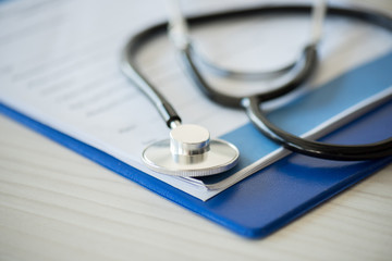 close up view of stethoscope lying on clipboard with diagnosis, selective focus