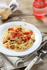 Pasta with tomatoes and mushrooms on a white plate