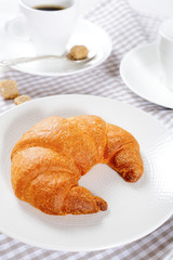 Croissant on a plate with coffee