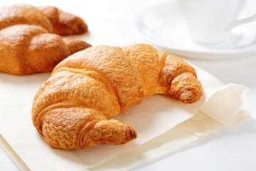 Two fresh croissant on paper