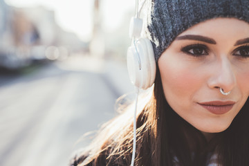 portrait young woman outdoor listening music with head phones - relaxing, getting away from it all, music concept