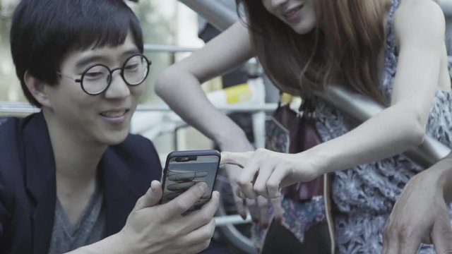 Man looking at smart phone with friend