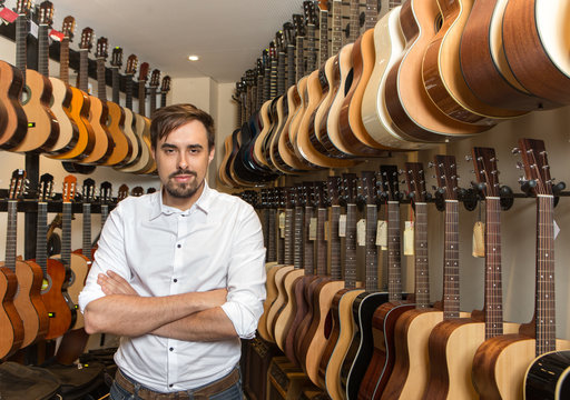 Portrait of man standing in guitar shop