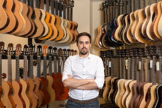Portrait of man standing in guitar shop