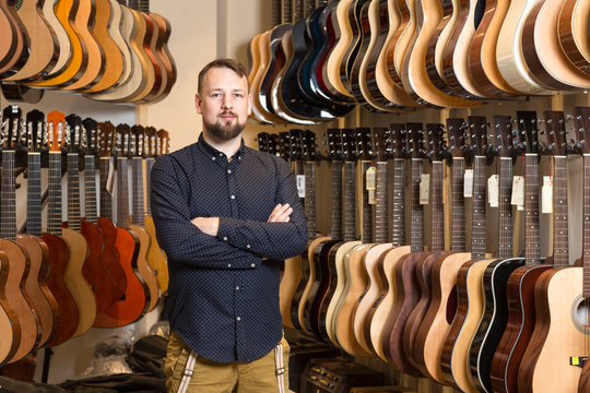 Portrait of a man standing in guitar shop