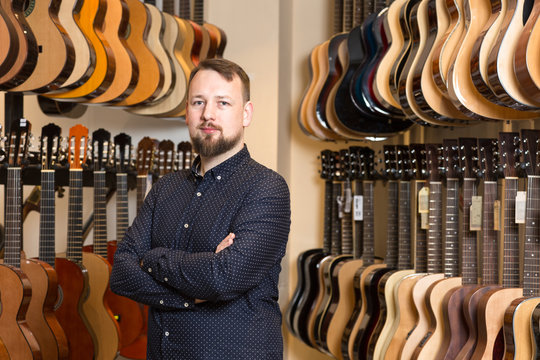 Portrait of a man standing in guitar shop